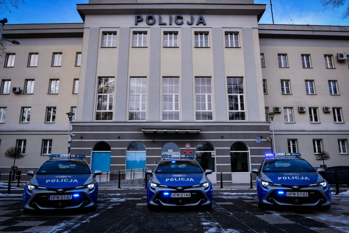 Trzy nowe radiowozy policyjne przez budynkiem komendy