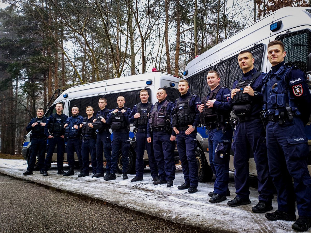 Kilkunastu policjantów w mundurach stoi w rzędzie