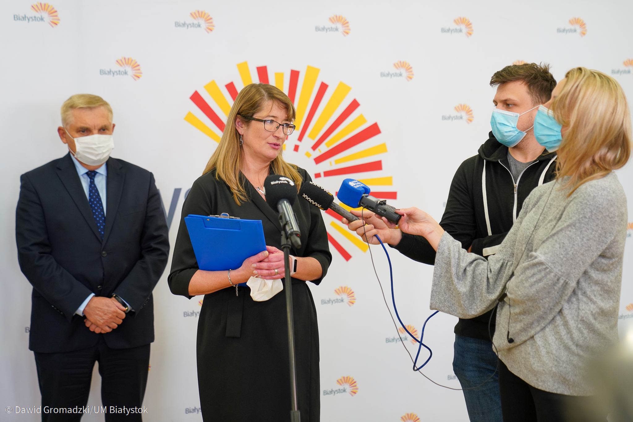 Kobieta mówi do mikrofonów trzymanych przez dziennikarzy