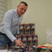Mężczyzna przy stole z gadżetami na WOŚP 2022