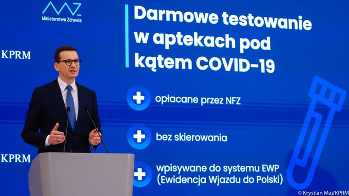 Premier na tle slajdu z prezentacji w czasie konferencji prasowej