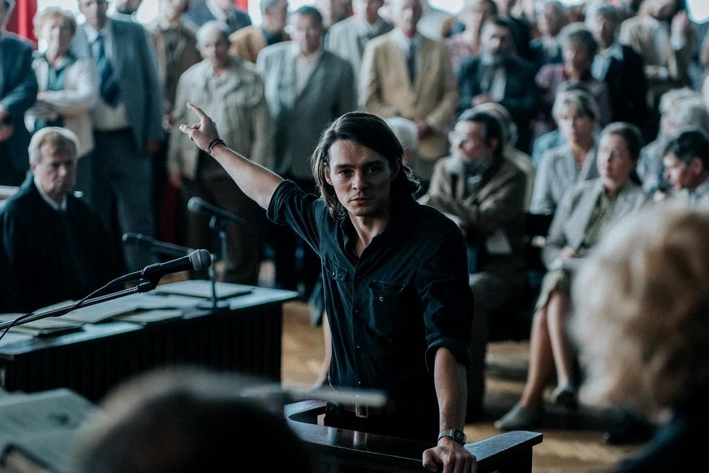 Kazd z filmu. Mężczyzna stoi w sali sądowej