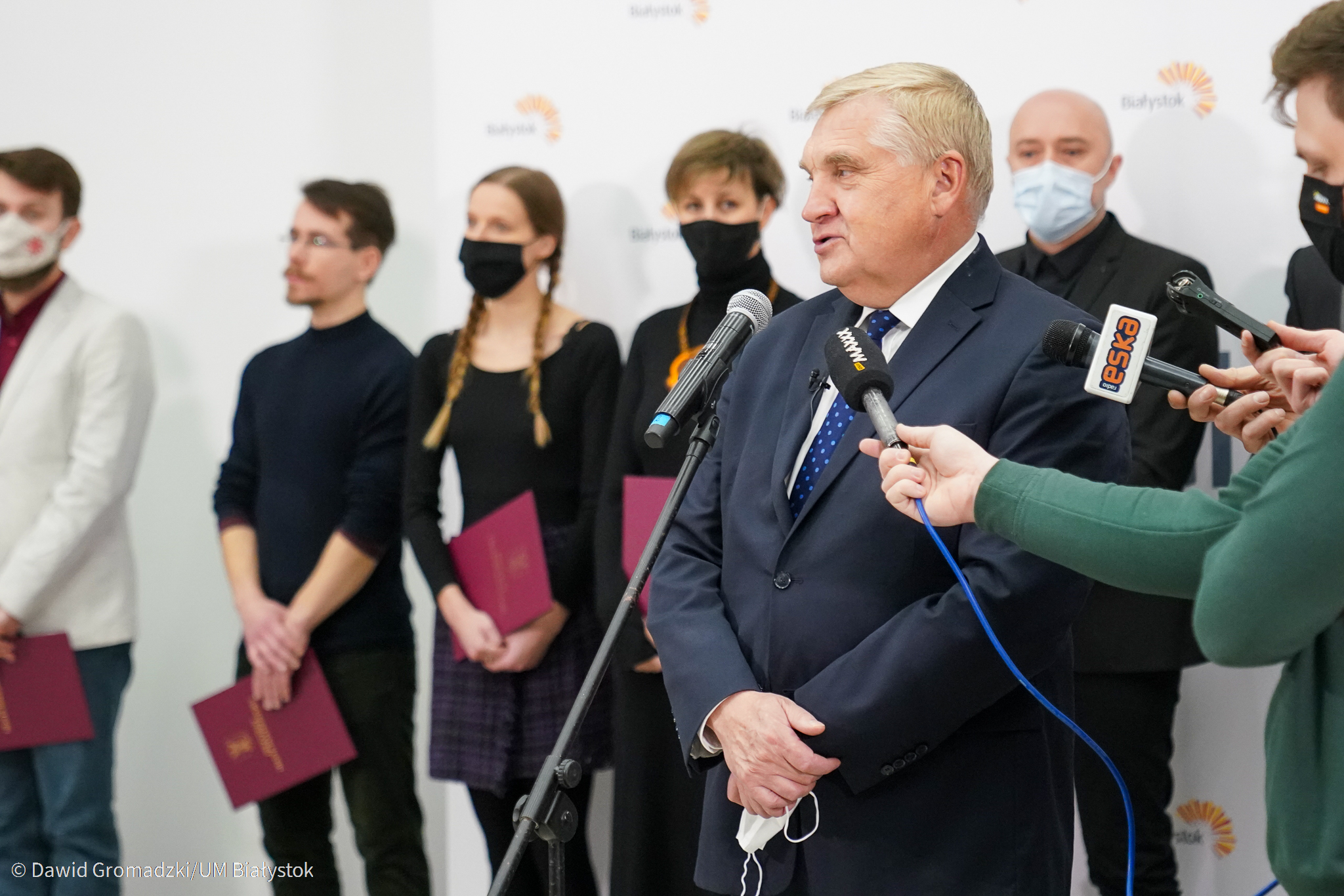 Prezydent mówi do mikrofonu, w tle stypendyści