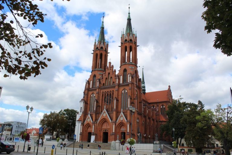 Zdjęcie fasady białostockiej katedry, która zbudowana jest z czerwonej cegły. Ma dwie wieże
