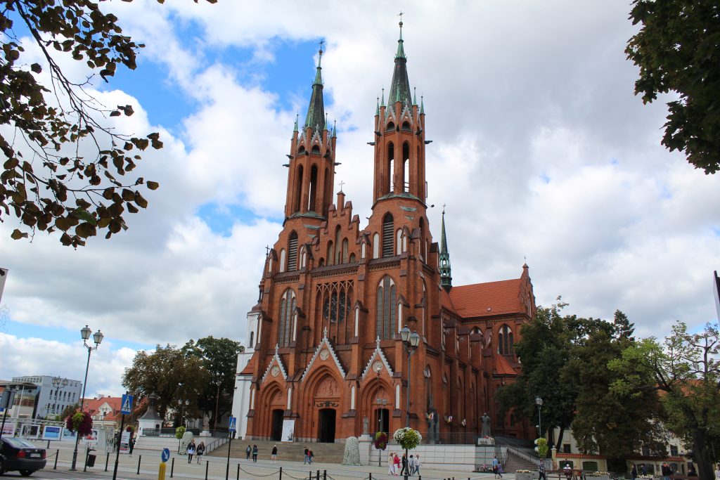 Zdjęcie fasady białostockiej katedry, która zbudowana jest z czerwonej cegły. Ma dwie wieże