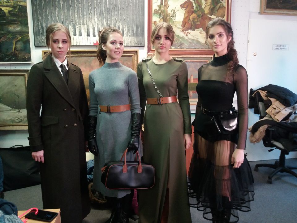 Kobiety modelki w militarnych ubraniach stoją na pokazie mody w muzeum wojska