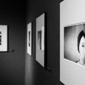 Czarno-białe fotografie w antyramach na ścianie muzeum