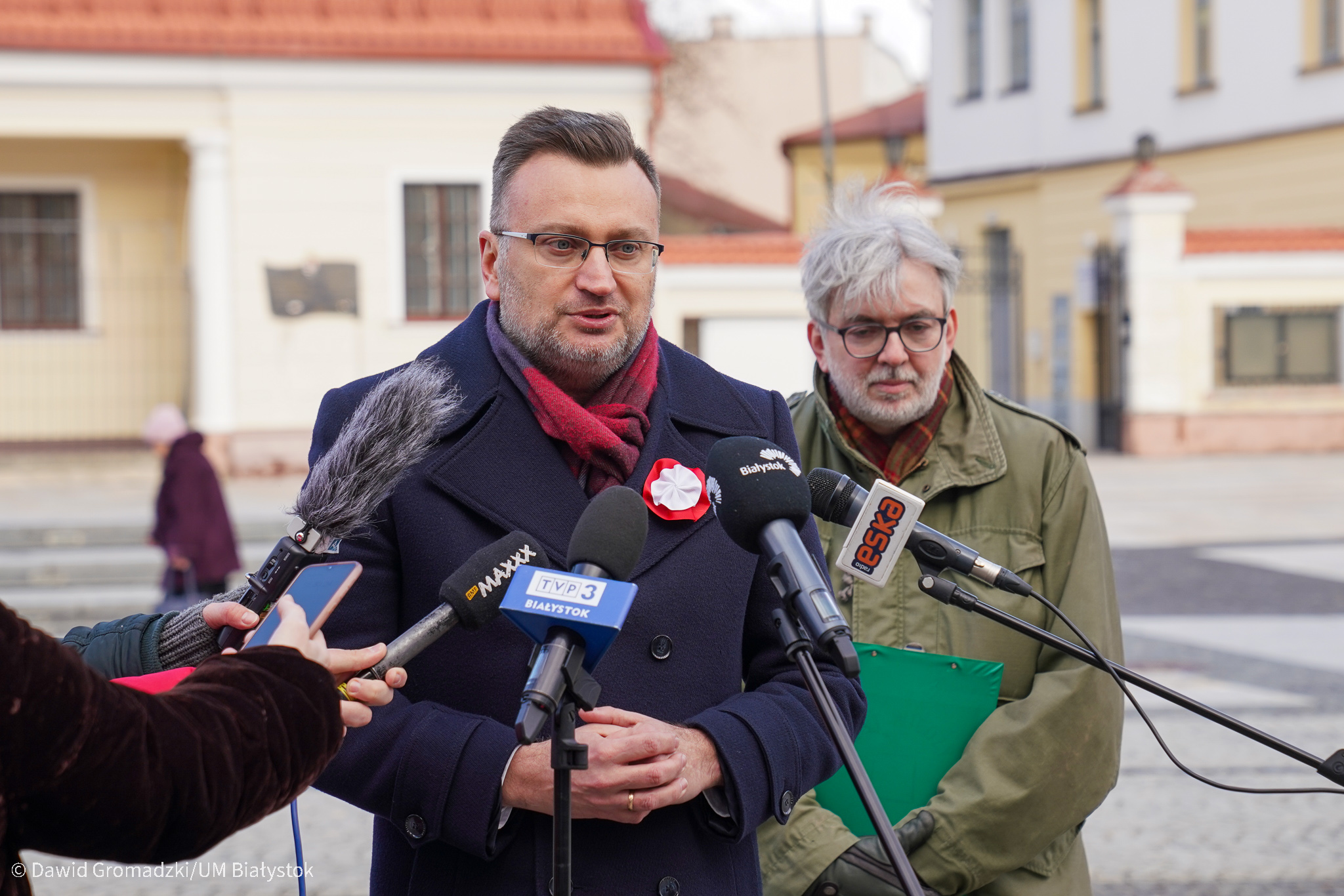 Dwaj mężczyźni stoją przy mikrofonie podczas konferencji przy pomniku Józefa Piłsudskiego