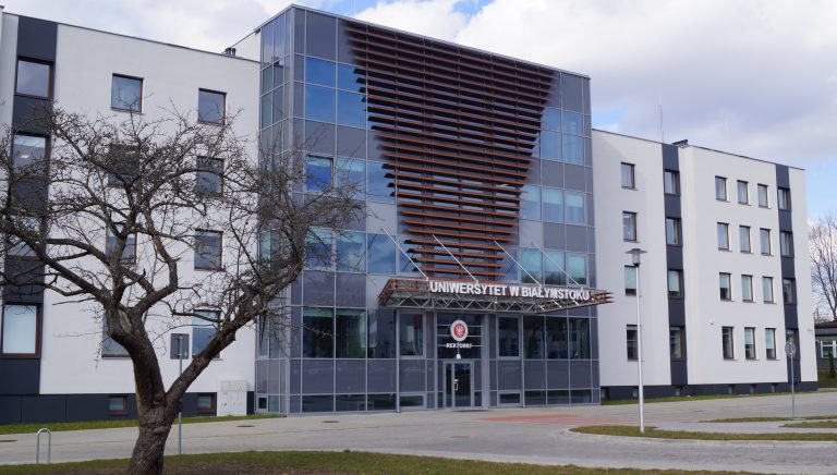 Nowoczesny biały budynek z przeszklonym środkiem