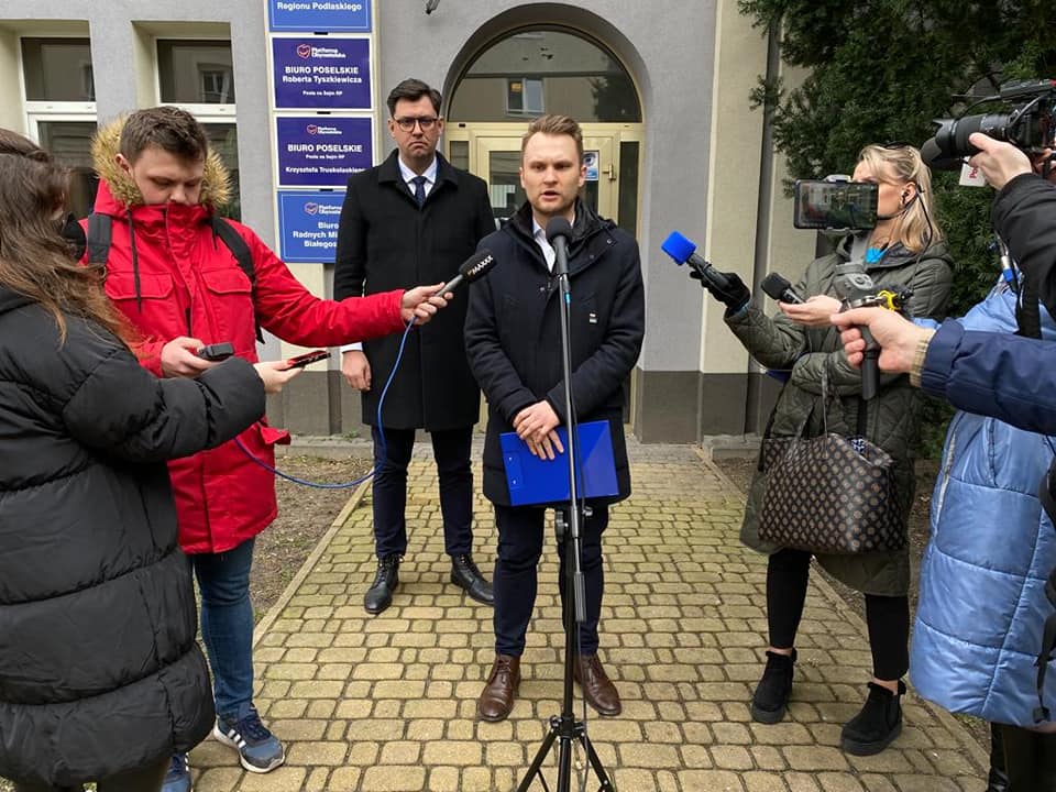 Do mikrofonu na statywie mówi mężczyzna