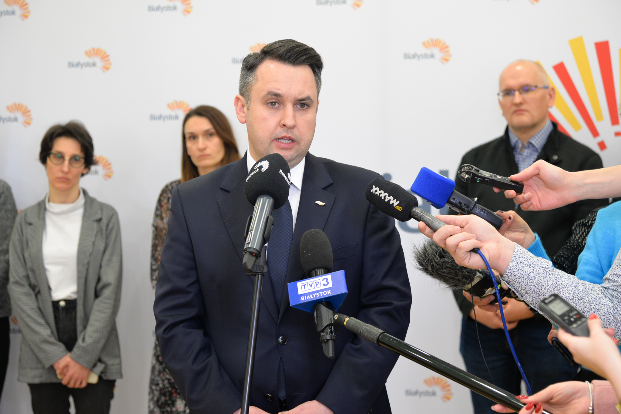 Mężczyzna mówi do mikrofonu podczas konfereencji prasowej
