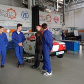 Uczniowei stoją przy zabytkowym samochodzie fiat 126p