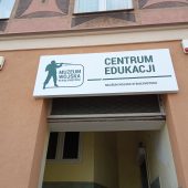 Szyd na ścianie i wejście do budynku Centrum Edukacji Muzeum Wojska Polskiego