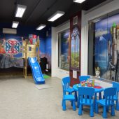 Centrum Edukacji dla najmłodszych, zainsccenizowany gród średniowieczny, krzesłka i stolik dla ddzieci, na ścianach namalowane zamki, okna
