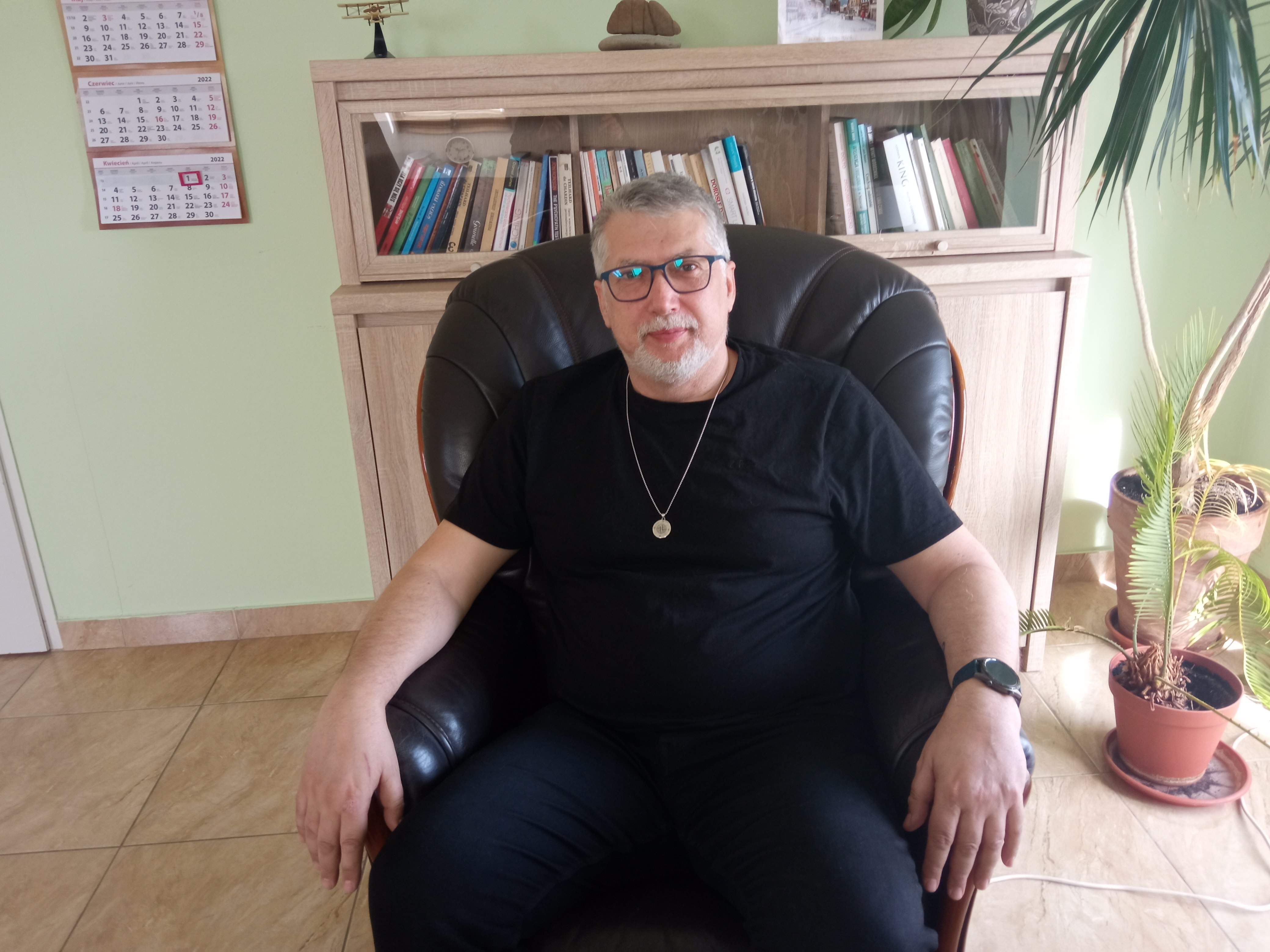Mężczyzna siedzi w fotelu w gabinecie