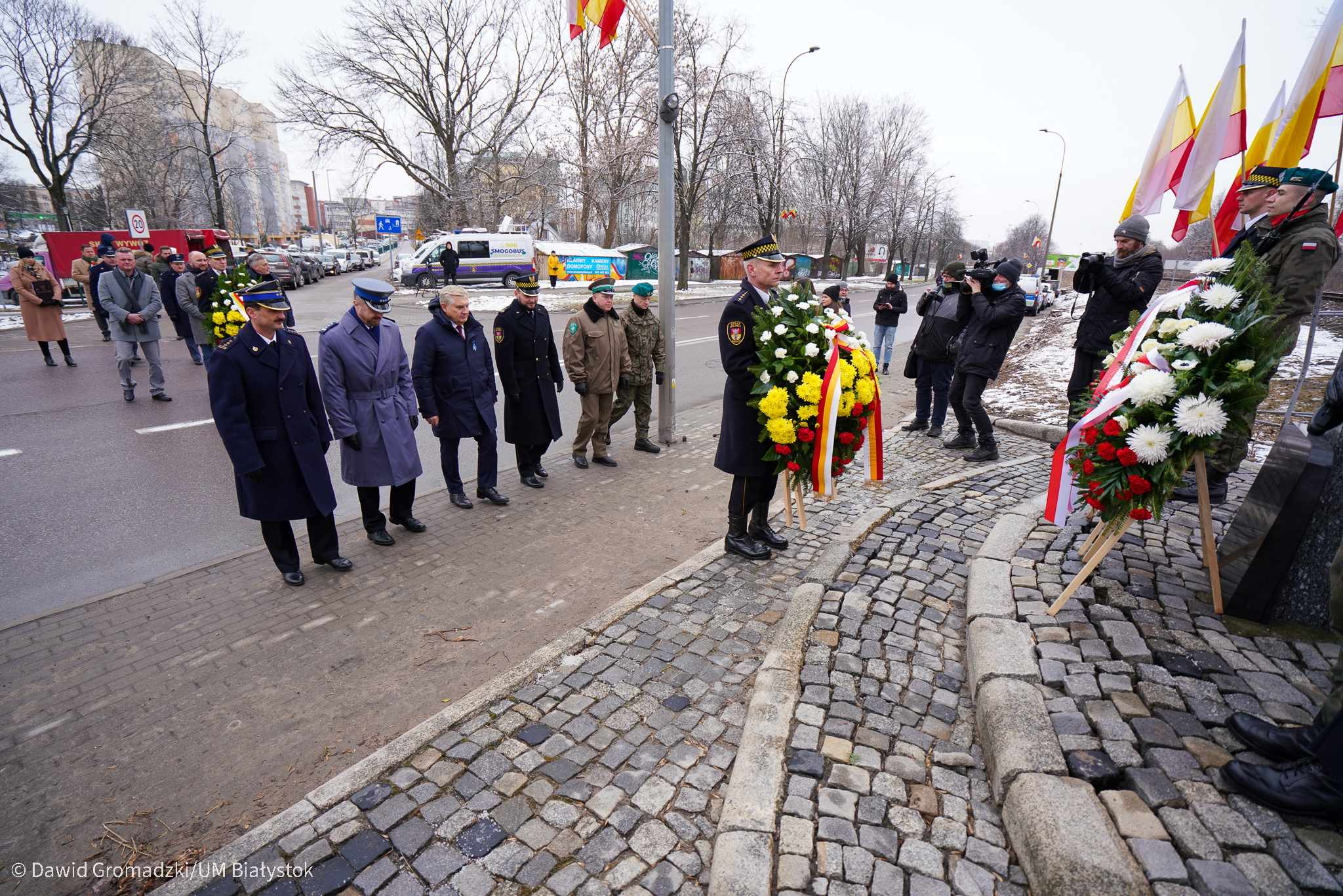 Uroczystości przy krzyżu, obecne na uroczystości osobą składają kwiaty