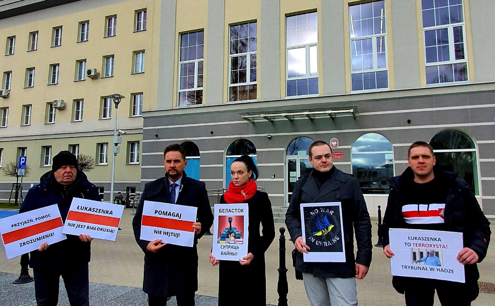 grupa ludzi stoi z transparentami