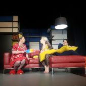 Dwie kobiety i mężczyna na scenie na kanapie