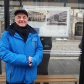 Mężczyna stoi przy wiacie przystanku autobusowego