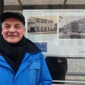 Mężczyna stoi przy wiacie przystanku autobusowego