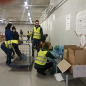 Wolontraiusze rozkładają dary w punkcie na stadionie