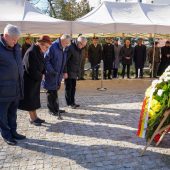 Ludzie składają wieńce pod pomnikiem