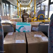 Autobus wypełniony kartonami z pomocą