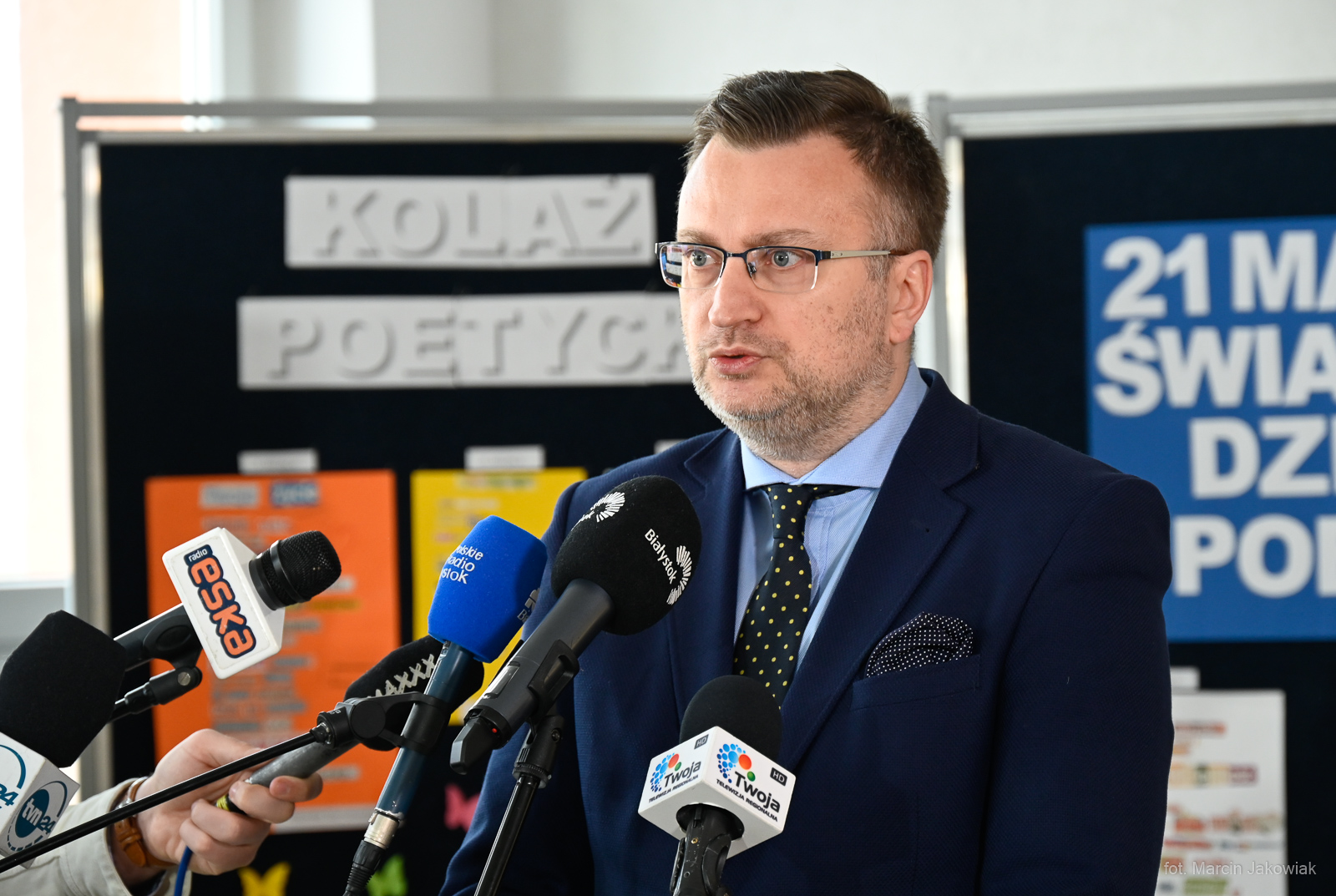 Mężczyzna mówi do mikrofonów dziennikarzy