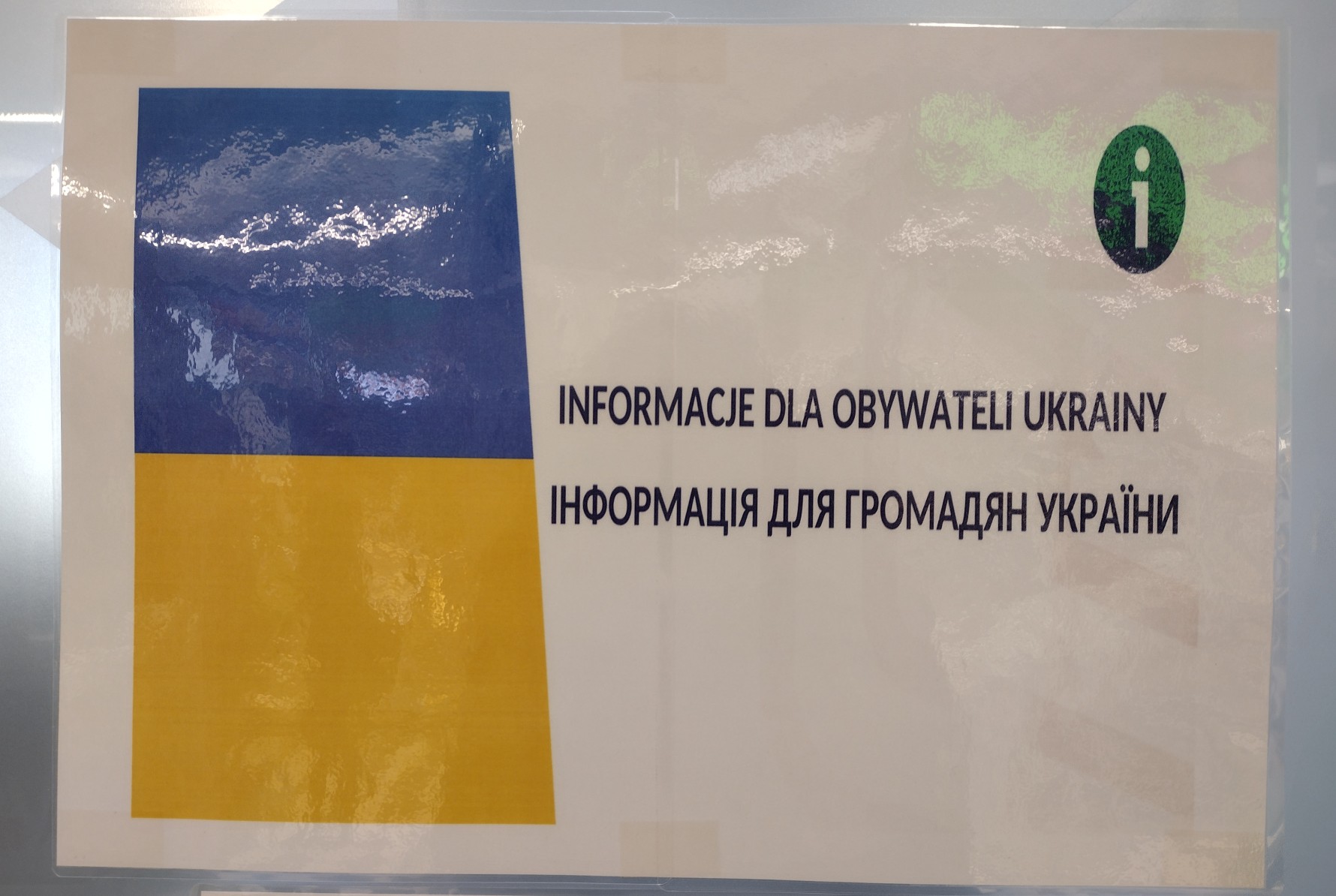 Na białej kartce na czarno jest napisane: Informacje dla obywateli Ukrainy. Obok, z lewej strony są barwy Ukrainy; na górze kwadrat ciemno-niebieski(kobaltowy)na dole kwadrat żółty