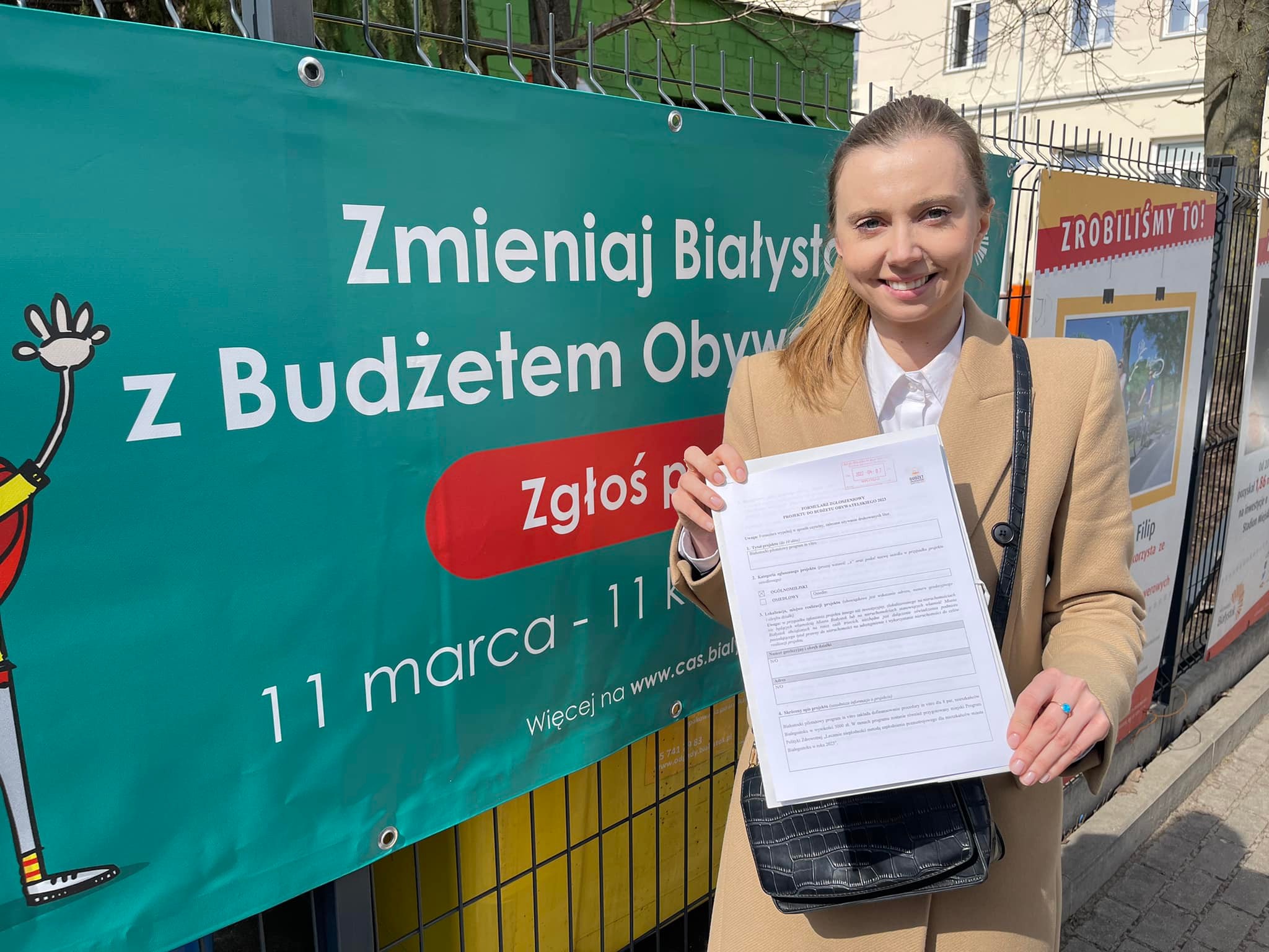 Radna Jowita Chudzik stoi z dokumentem w ręce