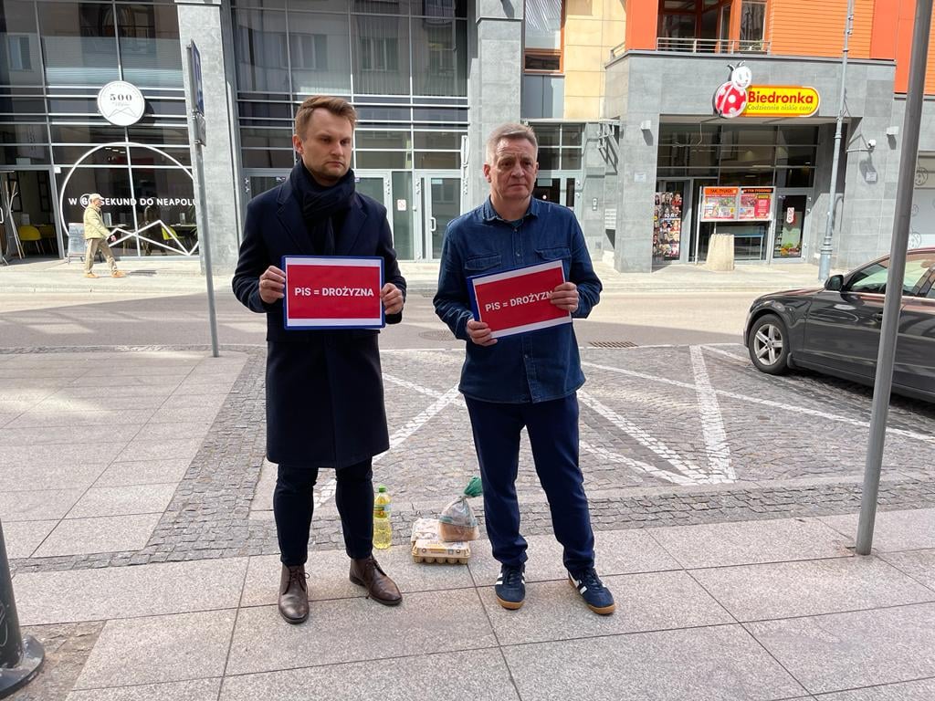 Dwaj mężczyźni przed siedzibą dyskontu
