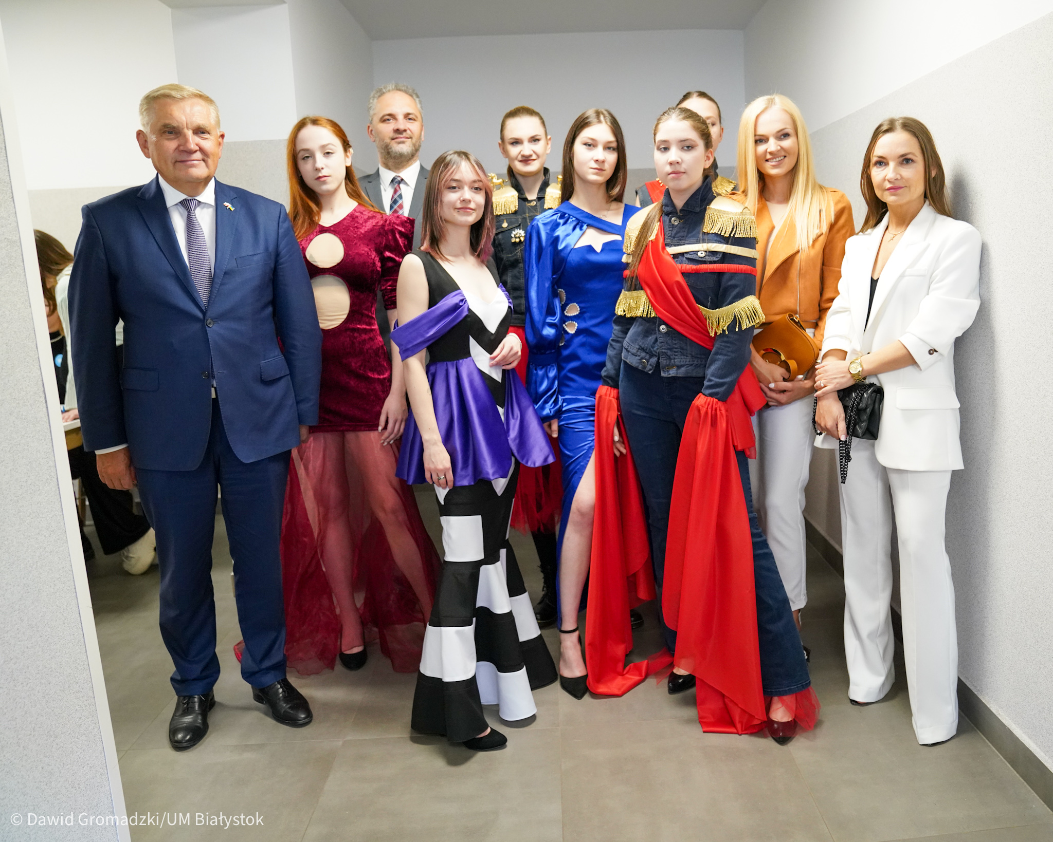 Modelki, prezydent i projektanta mody pozują do zdjęcia