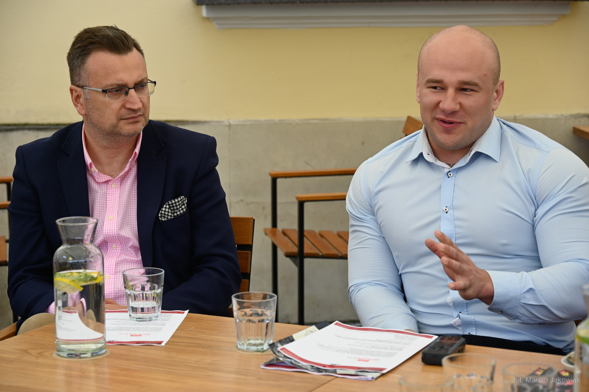 Dwaj mężczyźni siedzą przy stoliku