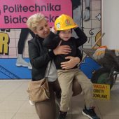 MAły chłopczyk w kasku siedzi na kolanach swojej mamy