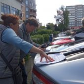Kobieta i mężczyzna przy samochodzie czytają papiery