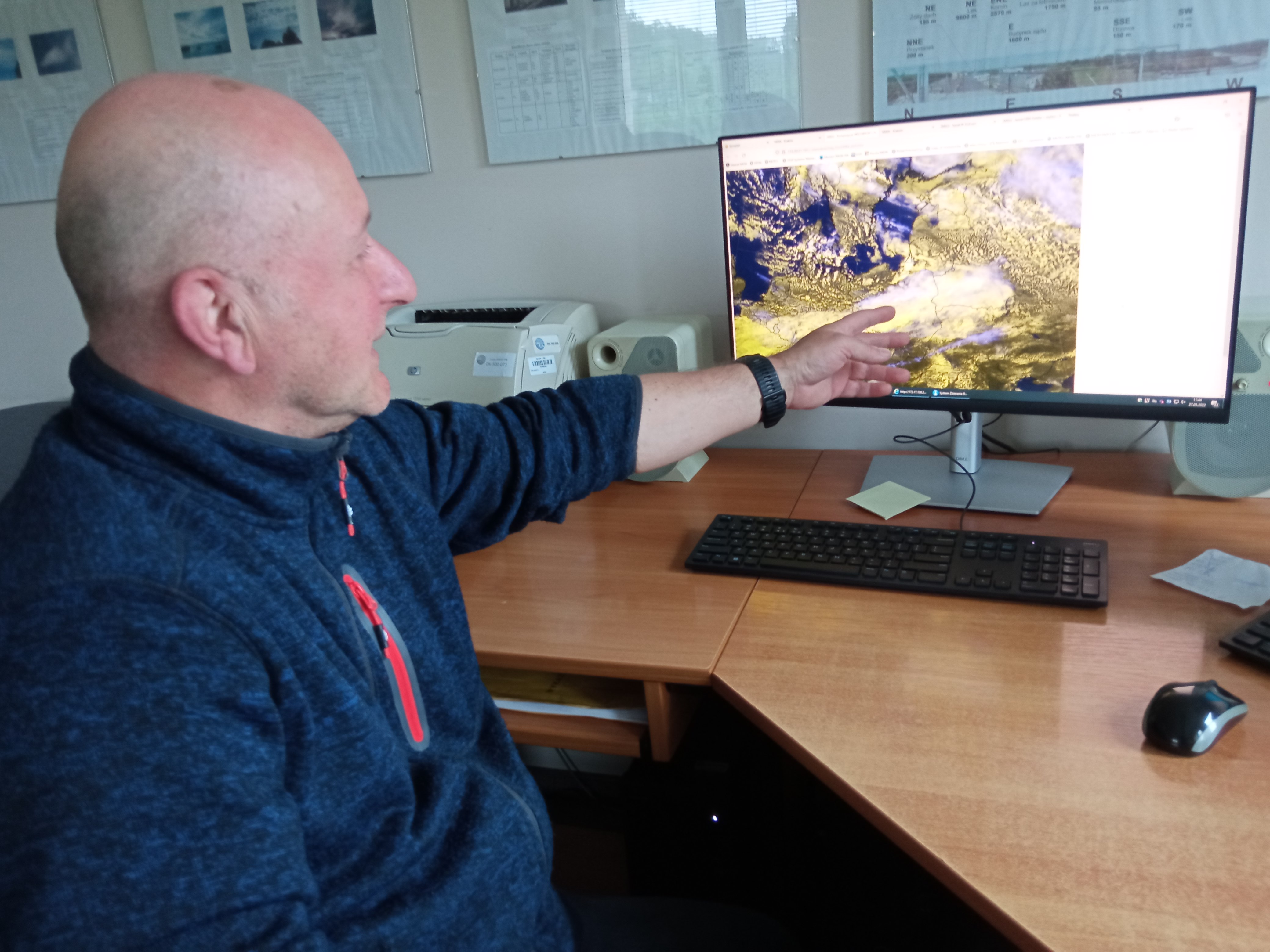 Mężczyzna pokazuje mapę pogody na ekranie komputera