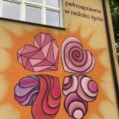 Kolorowy mural (serca w kształcie koniczynki) na ścianie budynku
