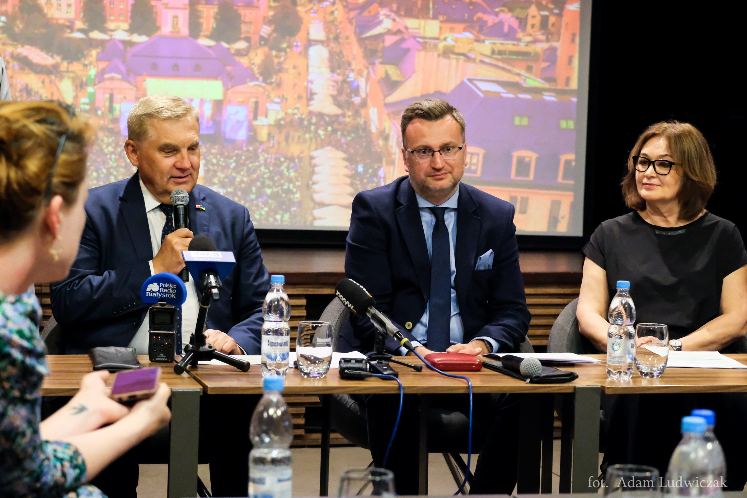 Przy stole siedzi kobieta i dwaj mężczyźni