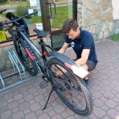 Mężczyzna ogląda rower i sprawdza łańcuchh
