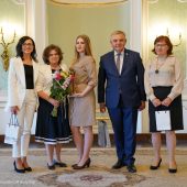 Na scenie stoi mężczyzna i wyróżnione kobiety