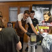 Mężczyzna prezentuje rower miksujący smoothie, obok obserwują młodzi ludzie