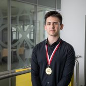 Chłopak stoi, na szyi ma medal