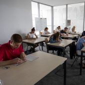 Uczniowie przy stolikach rozwiązują zadania