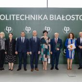 Kika osób stoi obok siebie podcas konferencji i uroczstości odpisania porozumienia
