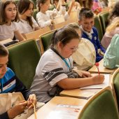 Uczniowie siędzą w auli