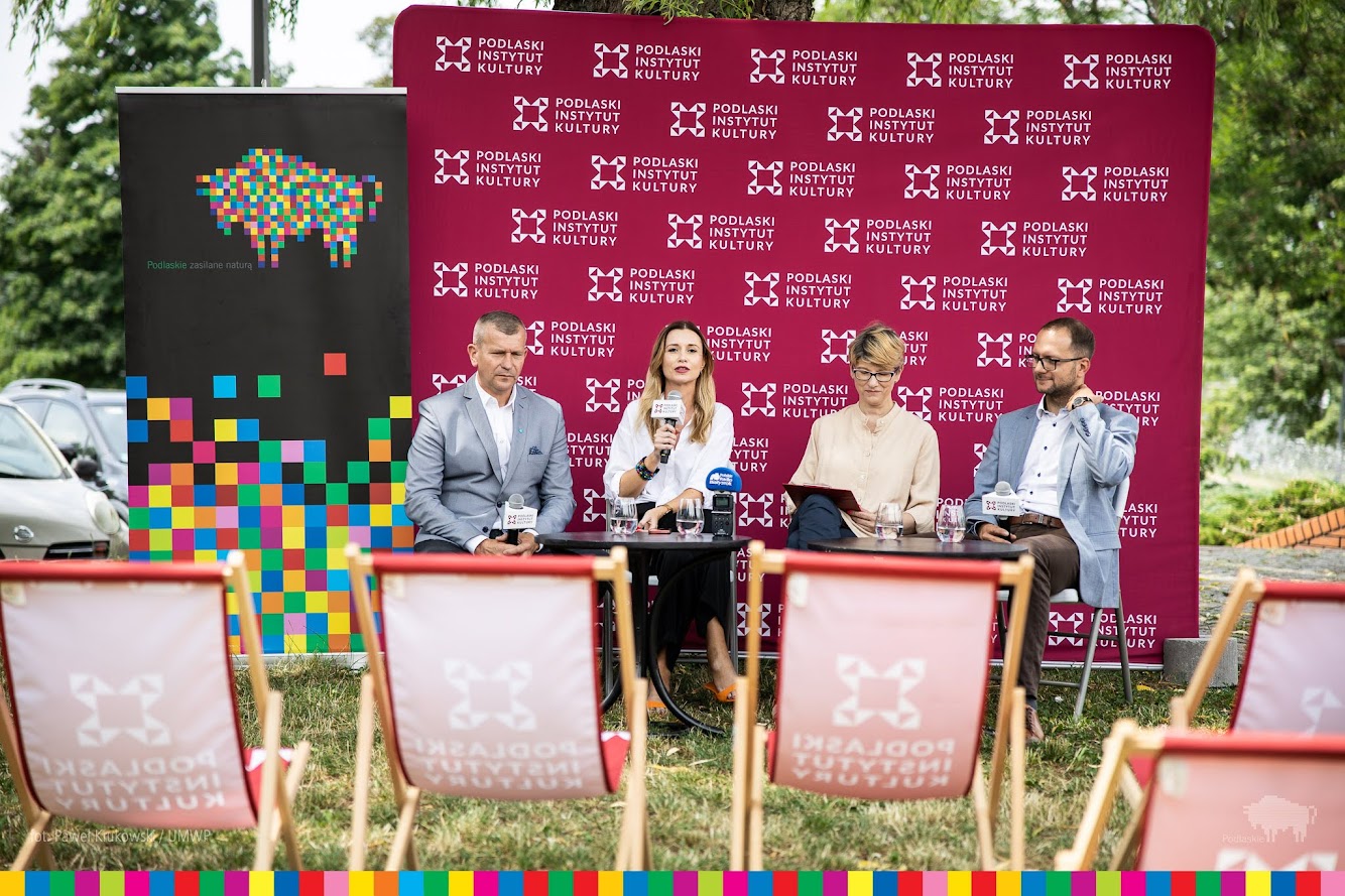 Cztery osoby siedzą na konferencji prasowej