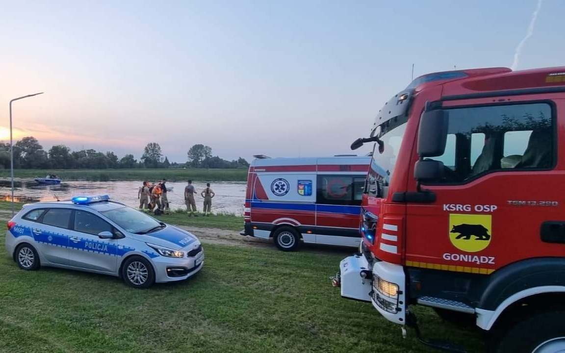 Wozy służb nad brzegiem rzeki