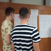Młodzi mężczyżni czytają wywieszone listy