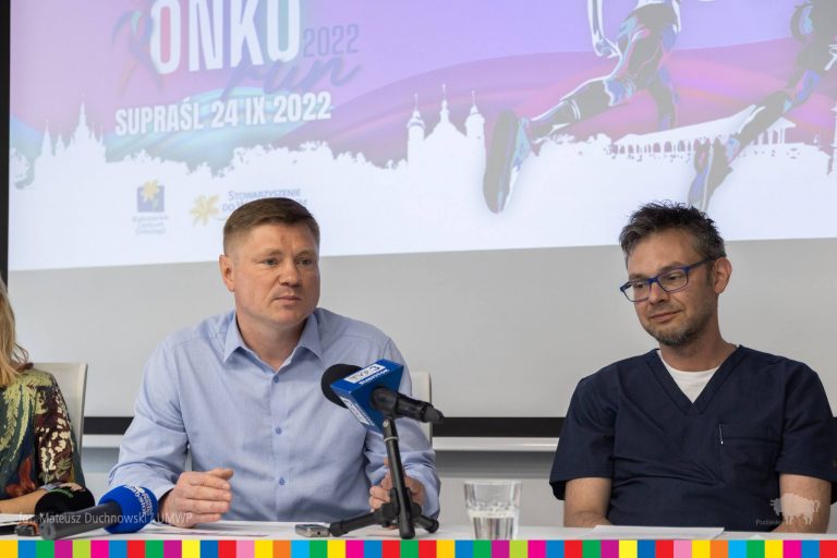 dwóch mężczyzn przed mikrofonami na konferencji