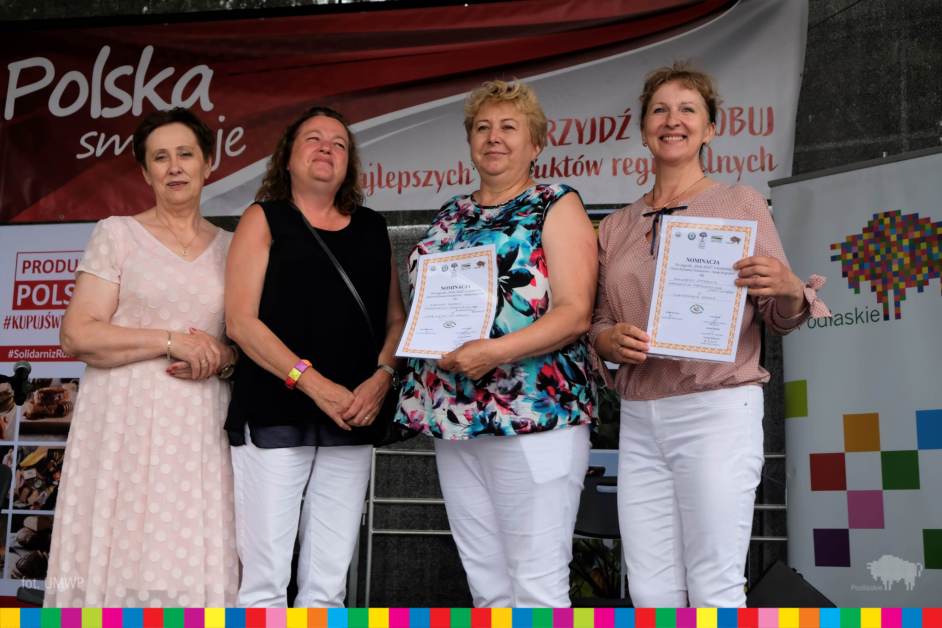 cztery kobiety stoją podzcas konkursu. Dwie trzymają dyplomu